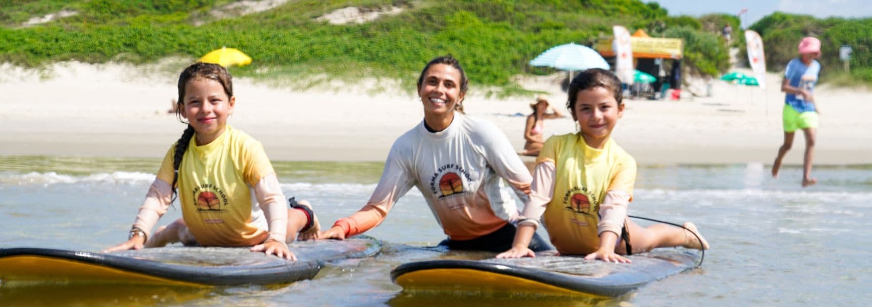 Foto de crianças em aula de surf